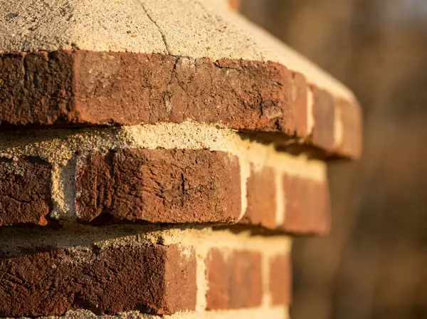 Macro-style illustration of brick chimney masonry texture with a corbelled, capped detail, a stylized material study, not a photograph of an actual chimney